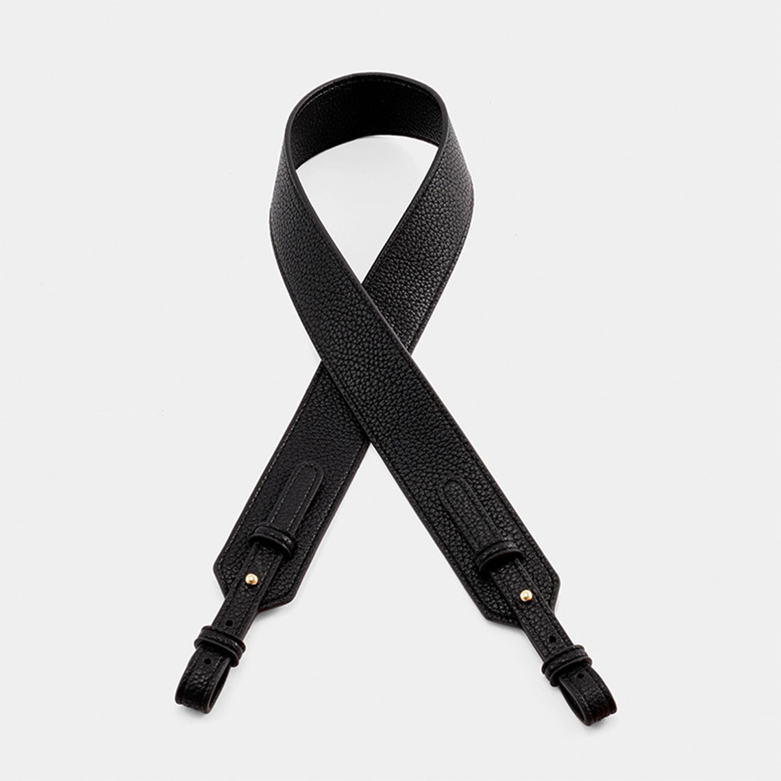 Black leather bags strap on a light gray background