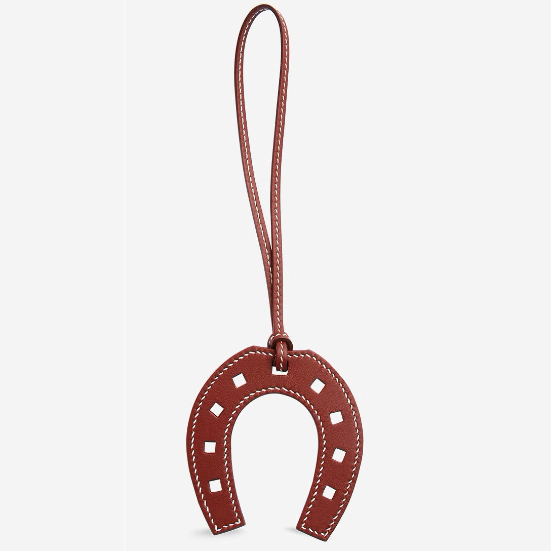 The horseshoe pendant keychain, made of genuine leather, is a high-end accessory suitable for various fashion bags, as well as a handmade car charm