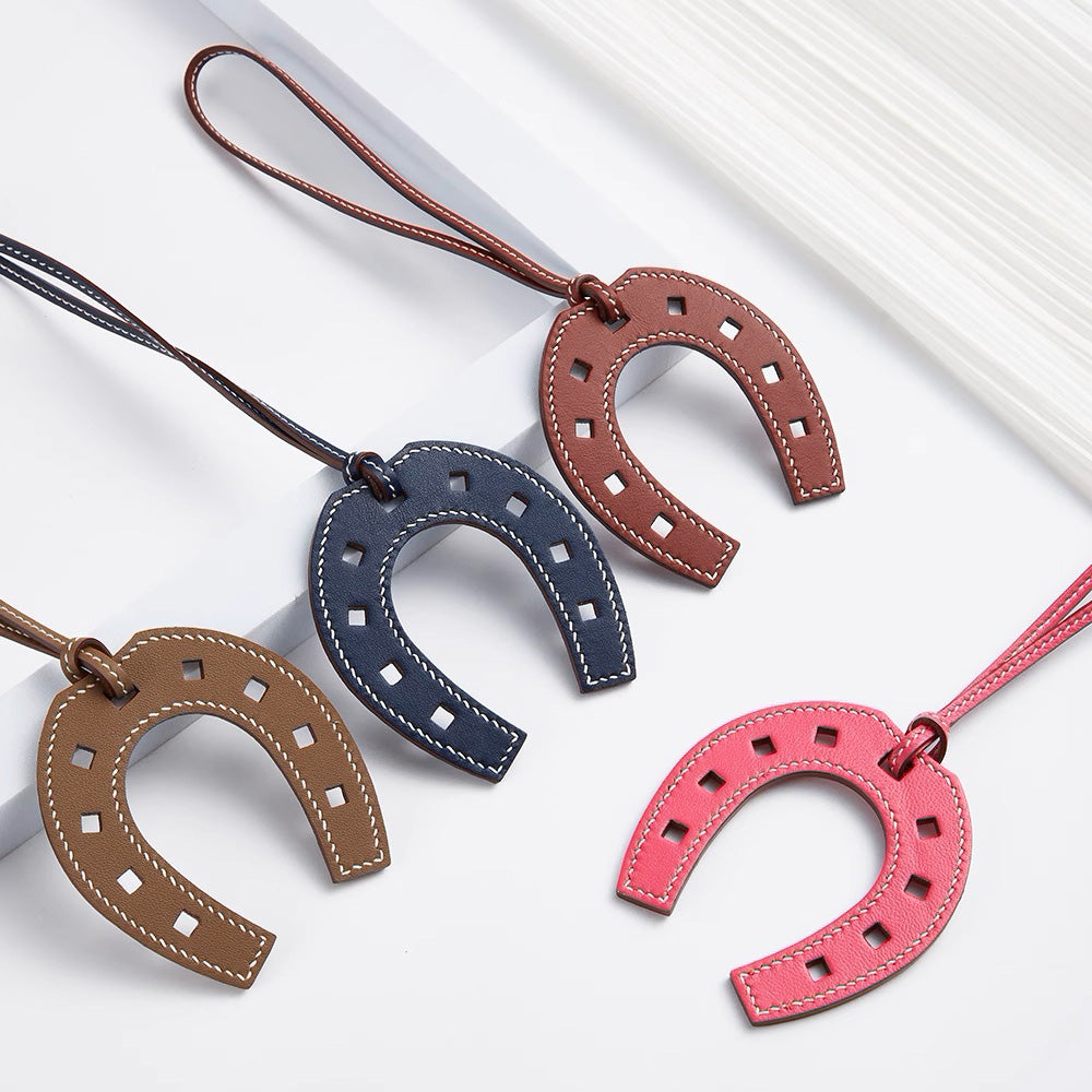The horseshoe pendant keychain, made of genuine leather, is a high-end accessory suitable for various fashion bags, as well as a handmade car charm