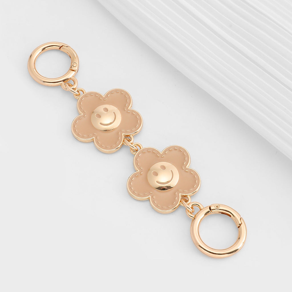 Metal accessory for underarm bags with a flower and smiley face design, 15 cm long strap extension chain